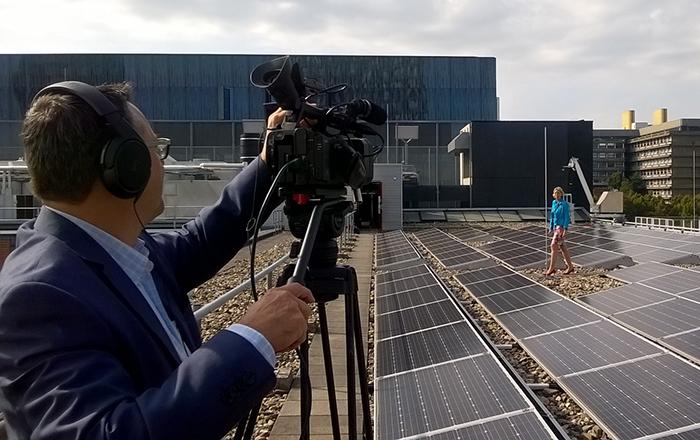 Tineke Zweed voor een video-opname over duurzaamheid, op het dak van Heidelberglaan 7