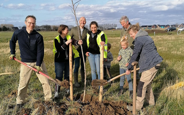 Het team plant een walnotenboom. Uiterst rechts (met spade): Annette Prinsen